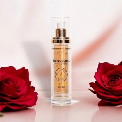 Flacon d'huile sèche précieuse visage, corps, cheveux, à la rose, dans un décor élégant avec roses rouges, soin nourrissant.