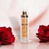 Flacon d'huile sèche précieuse visage, corps, cheveux, à la rose, dans un décor élégant avec roses rouges, soin nourrissant.