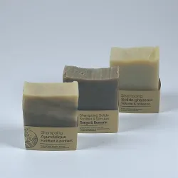 3 Shampoings solides Ayurvédique, Ghassoul, Sauge Romarin posé l'un derriere l'autre sur un fond neutre