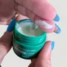 Crème hydratante anti-acné pot ouvert en main